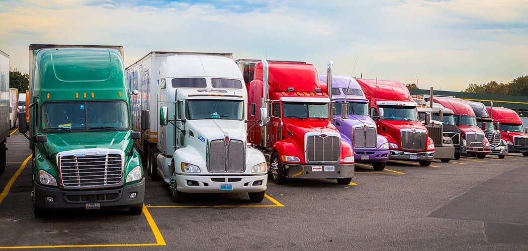 Tractor-trailers parked in marked bays at a truck stop